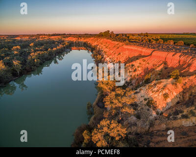 Erodendo scogliere di arenaria oltre il Fiume Murray al tramonto arancione brillante. Foto Stock