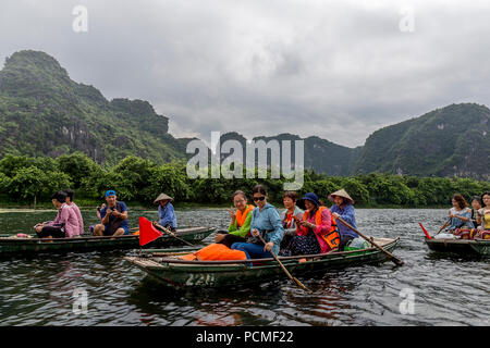 Barca carichi di turisti sul loro cammino nelle caverne del Vietnam. Foto Stock