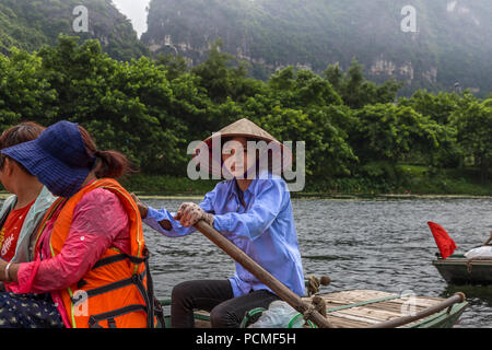 Editoriale: luglio 2017, Trang un Ninh Binh, Vietnam. Operatore in barca con i turisti in un tour. Foto Stock