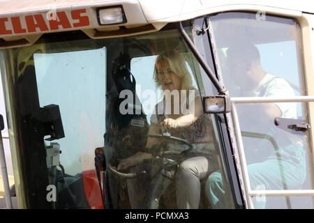 Ventschow, Germania. 03 Ago, 2018. Manuela Schwesig (SPD), Premier di Mecklenburg-Vorpommern, seduto accanto al contadino Mario Eichenbrot in un campo il trinciatore su un tour del raccolto della cooperativa Agrarprodukte Kleekamp. (Su 'Primo Ministro su un raccolto tour - visita a quattro aziende agricole' del 03.08.2018) Credito: Bernd Wüstneck/dpa/Alamy Live News Foto Stock