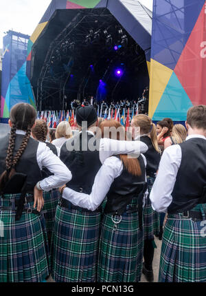 George Square; Glasgow, in Scozia. 03 agosto 2018. I giovani membri di una pipe band partecipa al pubblico di guardare e ascoltare la National Youth Pipe Band della Scozia di eseguire sul palco durante il Festival 2018. Il festival è in esecuzione in parallelo con i Campionati Europei; Glasgow 2018. Le bandiere dei paesi concorrenti in eventi sportivi sono nella parte anteriore del palco. George Square è un luogo libero con diversi live e attrazioni virtuale quotidianamente. Credito: Elizabeth Leyden/Alamy Live News Foto Stock