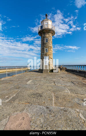 Storico Porto di Whitby faro sul molo Orientale con un cielo blu sullo sfondo. Foto Stock