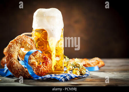 Boccali da birra e salatini su un tavolo di legno. Oktoberfest. Festa della birra. Foto Stock