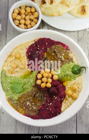 I vari sapori di hummus (barbabietola con aceto balsamico, jalapeno e coriandolo, e cricket farina) Foto Stock