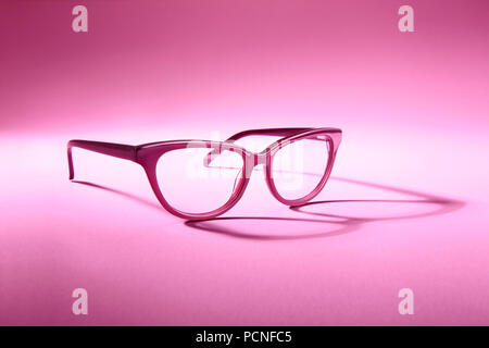 Pubblicità studio shot di rosa bicchieri con lunga ombra a sfondo rosa. Foto Stock