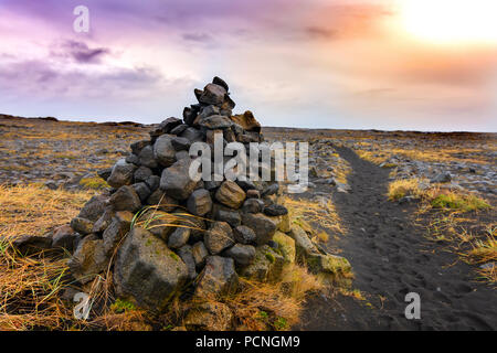 Cairns, cumuli di pietre vulcaniche in Islanda, vicino a sabbia vulcanica pathway Foto Stock