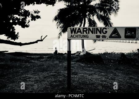 Coccodrillo segno di avvertimento su una spiaggia in bianco e nero, Cardwell, Queensland, Australia Foto Stock