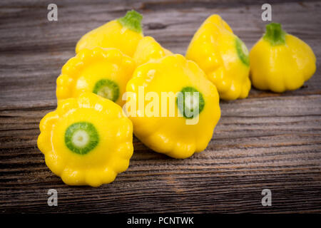 Piccole dimensioni patty pan patisson squash Sfondo legno Foto Stock