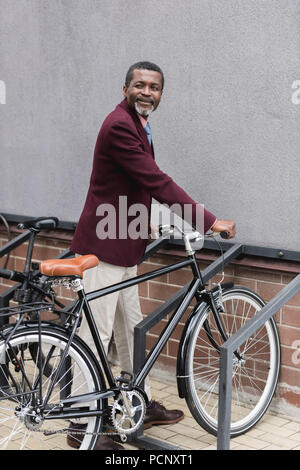 Felice coppia african american uomo con la bici in parcheggio per biciclette Foto Stock