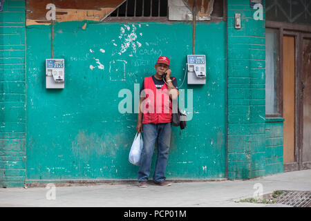 Caraibi Cuba, La Habana, Uomo al telefono nella parte anteriore del green parete esterna Foto Stock