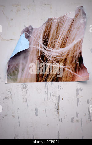 Close-up di un cartellone con dei frammenti di carta da poster e cartelloni pubblicitari. Foto Stock