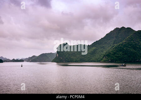 Le isole rocciose della baia di Halong in serata estiva sun Foto Stock