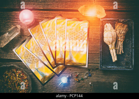 Le carte dei Tarocchi, radioestesia attrezzo, incenso e cristalli su una tavola di legno Foto Stock