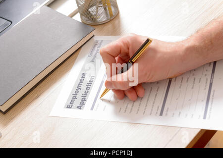 Il riempimento in vuoto l'occupazione modulo di domanda in mani su una scrivania Foto Stock