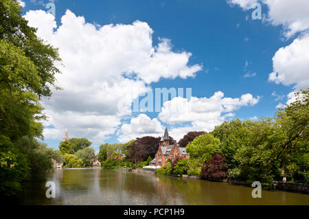 Il lago romantico Minnewater con la sua famosa casa con torri a sud di Bruges, Belgio. Foto Stock