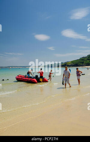 Un self drive con una barca a motore che vengono restituiti per la spiaggia di St Ives in Cornovaglia su un giorno d'estate. Foto Stock