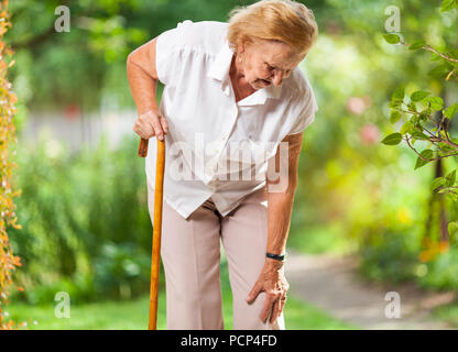 Donna anziana negli anni ottanta con un bastone da passeggio Foto Stock