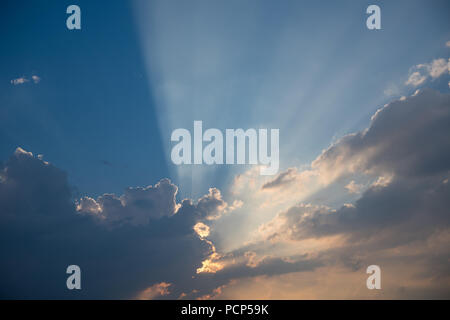 Sole che splende dietro le nuvole di tuono su una sera d'estate. North Yorkshire, Regno Unito. Foto Stock