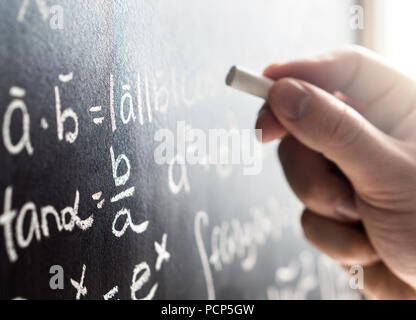 Insegnante iscritto alla lavagna con gesso. Studenti e lavagna. Professore nella scuola, college o università in aula. Scienza e Istruzione concetto. Foto Stock