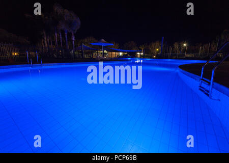 Night Shot della piscina di lusso incandescente in blu Foto Stock