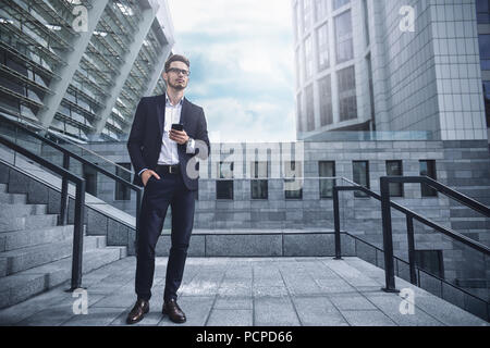 Bel imprenditore di successo in elegante abito all'aperto a camminare sulla via della città. Foto Stock