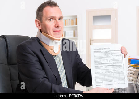 Imprenditore a lavorare indossando il rinforzo del collo con insirance flaim forma in mani Foto Stock