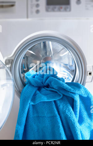 Moderna macchina di lavaggio caricata con asciugamano blu Foto Stock