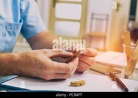 Medico audiologist azienda protesi nella sua mano Foto Stock