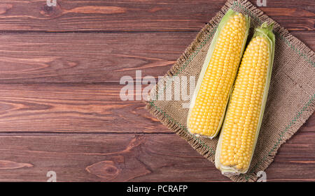 Mais dolce su pannocchie su sfondo di legno Foto Stock