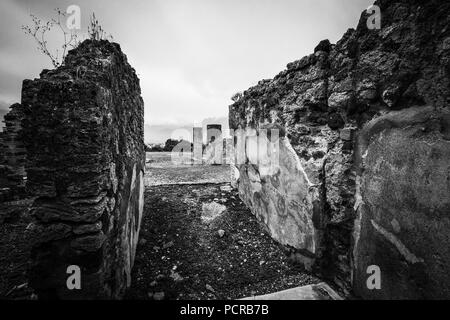 Parete e due colonne in una piazza presso le rovine di antiche città di Pompei e vicino a Napoli, Italia Foto Stock