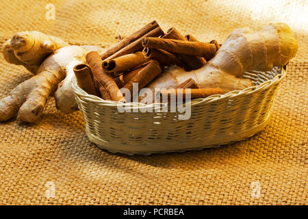 Bastoncini di cannella di radice di zenzero in un cesto su tela Foto Stock