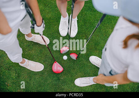 Vista aerea del femminile giocatori di golf con il club di golf in piedi sul prato verde con palla da golf in medio Foto Stock