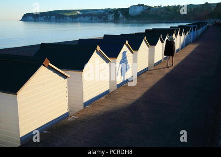 Le ombre delle persone che passano dalla spiaggia bianca di capanne in città costiera di Seaton in East Devon Foto Stock