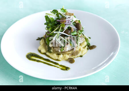 Purea di patate con bistecca di pesce e insalata su piastra bianca Foto Stock