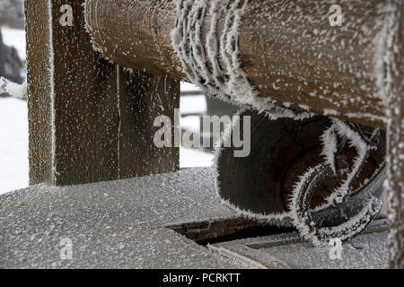 Close up congelati della benna in metallo seduta sul pozzo di acqua durante il periodo invernale in Marijampole, Lituania. Foto Stock