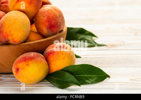 Pesche con foglie di close-up sul tavolo Foto Stock