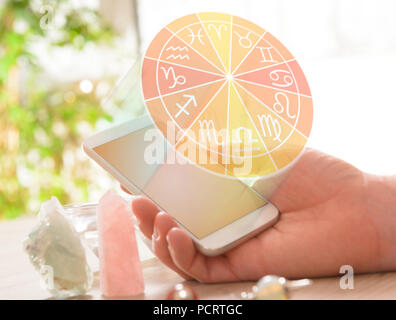 Segni zodiacali e smart phone in mano. Concetto moderno di astrologia. Foto Stock