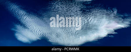 Una spettacolare inspirational vivacemente colorato atmosferica cielo nuvoloso cloudscape dotato di un cloud Cirrostratus formazione in una metà del cielo blu. Foto Stock