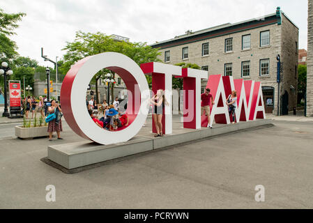 Ottawa, Ontario, Canada. I turisti che pongono a Ottawa lettere su York Street appena ad est di Sussex Drive in Byward Market district. Foto Stock