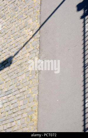 Primo piano di una passerella su un ponte il cui ringhiera proietta ombre simmetrica Foto Stock