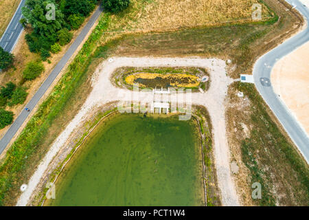 Obliquamente aerially prese nel bacino anteriore o stilling bacino di un bacino di ritenzione dell'acqua piovana in una nuova area di sviluppo. Foto Stock