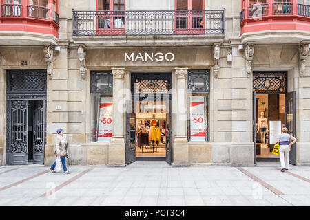 Gijon, Spagna - 6 Luglio 2018: gli amanti dello shopping a piedi passato Mango shop su Calle corrida. Questa è una delle principali vie dello shopping. Foto Stock