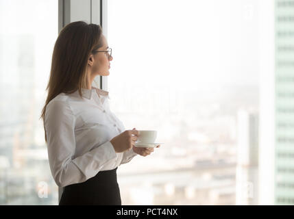 Riflessivo ceo godendo di vista da finestra di bere il caffè Foto Stock