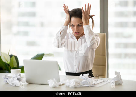Sottolineato lavoratore di sesso femminile che farsi prendere dal panico non si riesce a terminare il lavoro fino alla morte Foto Stock
