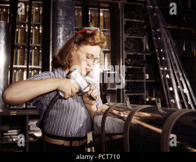 Il funzionamento di un trapano a mano presso la North American Aviation, Inc., [a] donna sta lavorando in superficie di controllo reparto assemblaggio di una sezione del bordo di attacco per il empennage orizzontale di un piano, Inglewood, Calif. - Ottobre 1942 Foto Stock