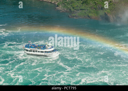 Cascate del Niagara, Canada-frontiera USA. Tour in barca la Domestica della Foschia sul fiume Niagara in estate sotto un arcobaleno avvicinando le Cascate Ferro di Cavallo Canadesi. Foto Stock