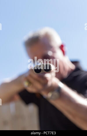 Uomo maturo mirando a doppia canna di fucile, STATI UNITI D'AMERICA Foto Stock