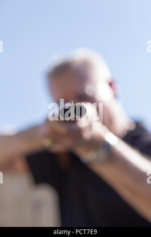 Uomo maturo mirando a doppia canna di fucile, STATI UNITI D'AMERICA Foto Stock