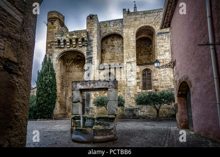 Cruzy, Place de l'Église, Chiesa di Église Sainte Eulalie de Mérida fu costruito in epoca romana - stile gotico tra il X e il XIV secolo, di fronte ad essa una vecchia fontana di pietra Foto Stock