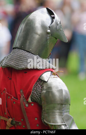 Cavaliere medievale in armatura in acciaio si erge con la sua schiena Foto Stock